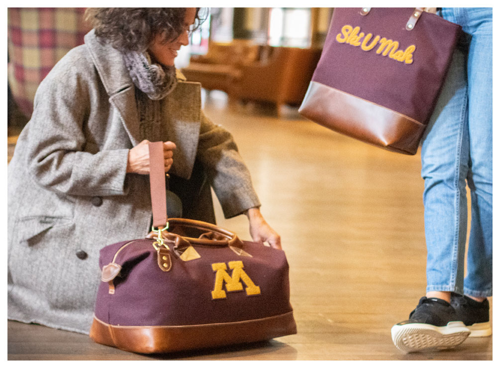 women with high-end U of M branded hand bags